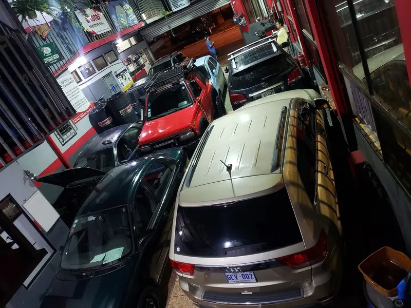 El taller de noche visto desde arriba, con varios carros en reparación